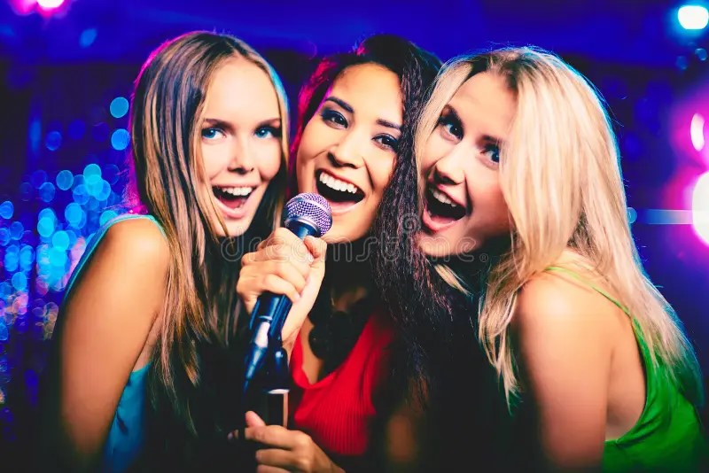 Tres chicas felices cantando karaoke en Puebla